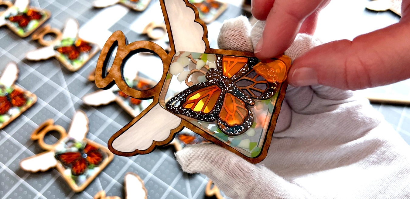 Jen fits the orange acrylic pieces into the design of the Monarch Butterfly Ornament from the Mother’s Angels® collection. This step in the design process brings the vibrant colors and patterns of real monarch butterflies to life, making each angel figurine truly captivating.