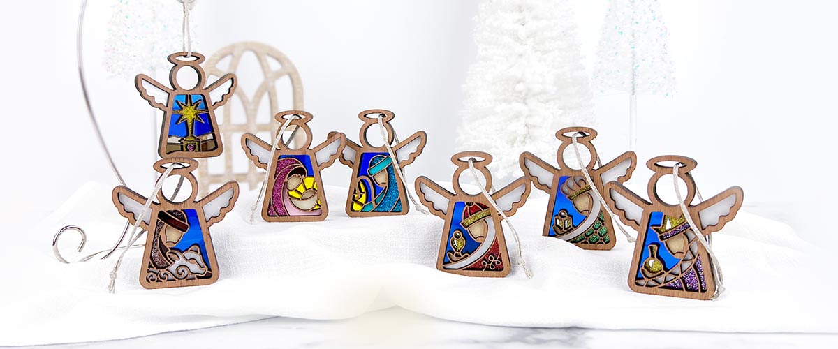 Handcrafted Mother’s Angels® Christmas Nativity scene featuring seven angel ornaments, including Mary, Joseph, and baby Jesus, displayed on a festive holiday table.
