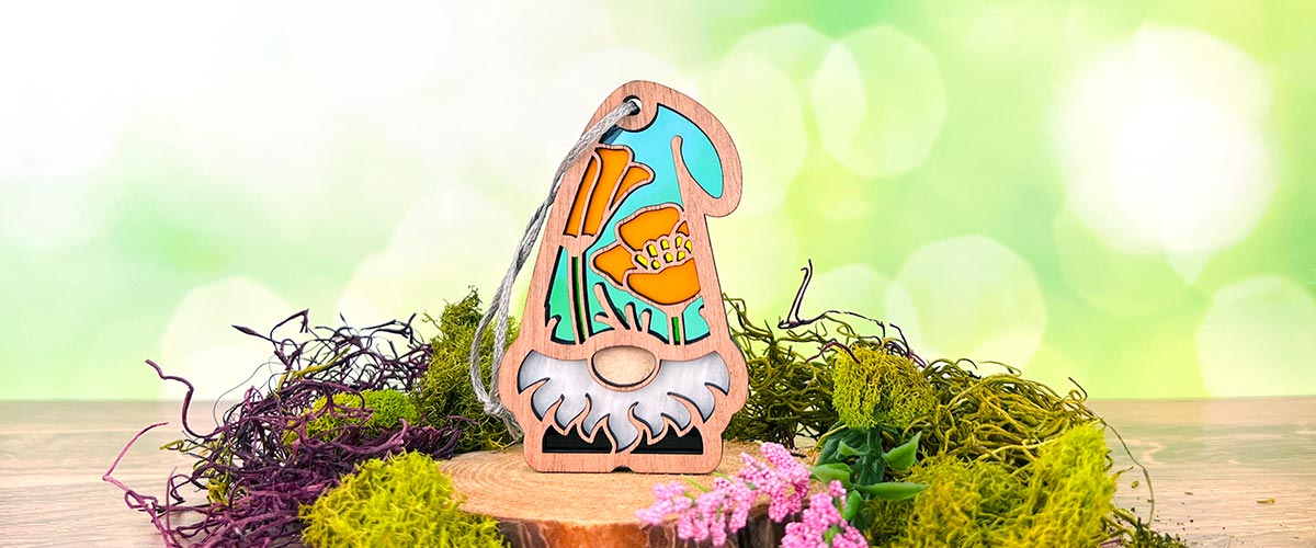 Forged Flare® California Poppy Gnome, a handcrafted gift idea for white elephant gift exchanges, featuring a vibrant orange poppy on a wooden stand with moss.