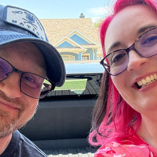 Jen and Chris Street sitting in the back of a Tesla Cybertruck, ready for the Doom: The Dark Ages launch party in downtown Dallas, May 2025, celebrating the iconic video game with bold style and geeky excitement.