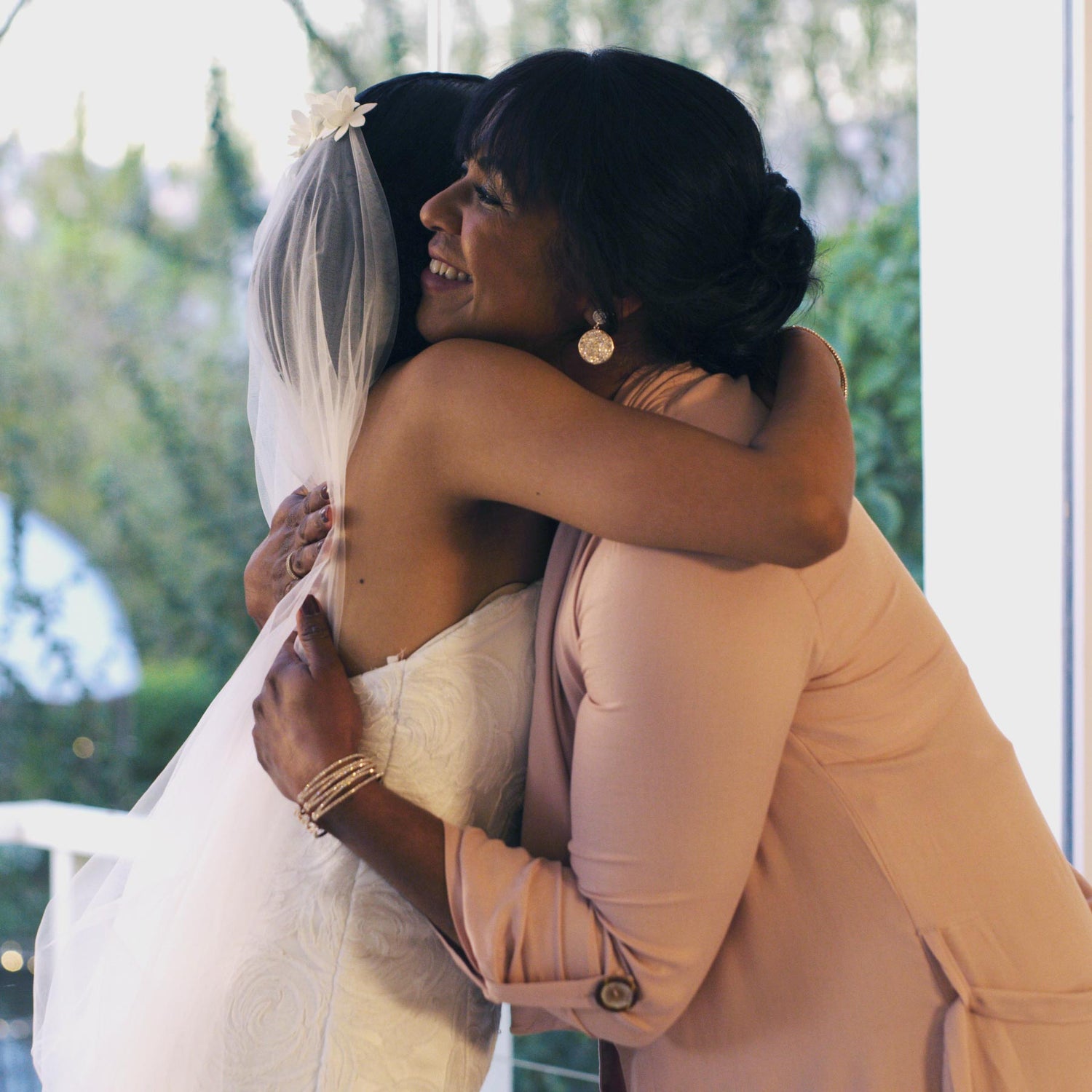 Daughter in a wedding dress and her mother hug before the wedding.