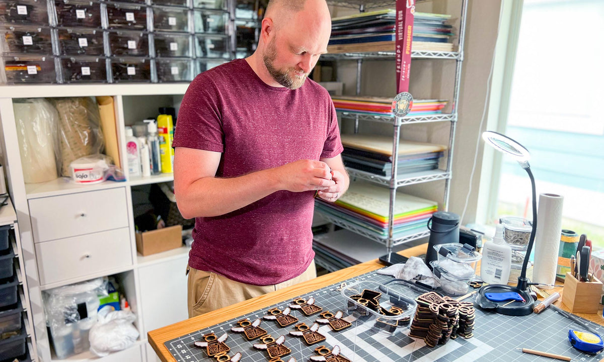 Chris working on assembling monarch butterfly ornaments in a workshop setting.