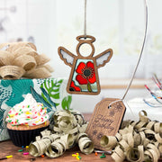 The Forged Flare® Mother's Angels® Poppy Ornament (3.5" angel figurine) from Amazon adds a festive touch above a birthday scene with a cupcake, gold ribbon, gift box, and "Happy Birthday" tag—ideal for special celebrations.