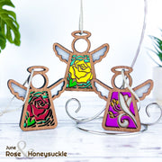 The Forged Flare® Mother's Angels® Red Rose Ornament features a stained glass-style angel figurine (3.5" H) with unique imperfections, displaying a red rose design and “June Rose & Honeysuckle” in the corner.