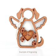 The Forged Flare® Forever In My Heart Dog Angel Ornament features a wooden dog with wings, paw prints, and a heart engraved with "Daisy 2016-2026." A perfect personalized dog mom or dog lover gift. Example engraving shown.