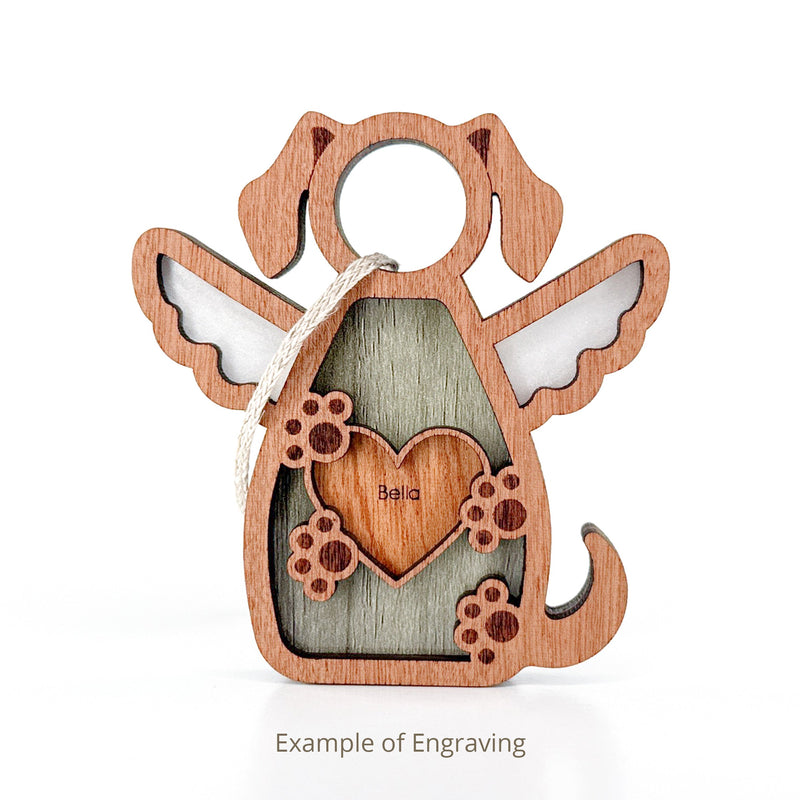 The Forged Flare® Forever In My Heart Dog Angel Ornament features a wooden design with wings, paw prints, a heart engraved with "Bella", and a top string. Perfect as a dog mom gift. Text reads "Example of Engraving".