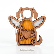 The Forged Flare® Forever In My Heart Dog Angel Ornament features a wooden dog with angel wings, heart, and paw prints. Hung by a string, it's ideal as a personalized gift for dog lovers. Text reads "Butterscotch Haze".