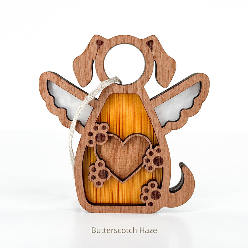 The Forged Flare® Forever In My Heart Dog Angel Ornament features a wooden dog with angel wings, heart, and paw prints. Hung by a string, it's ideal as a personalized gift for dog lovers. Text reads "Butterscotch Haze".