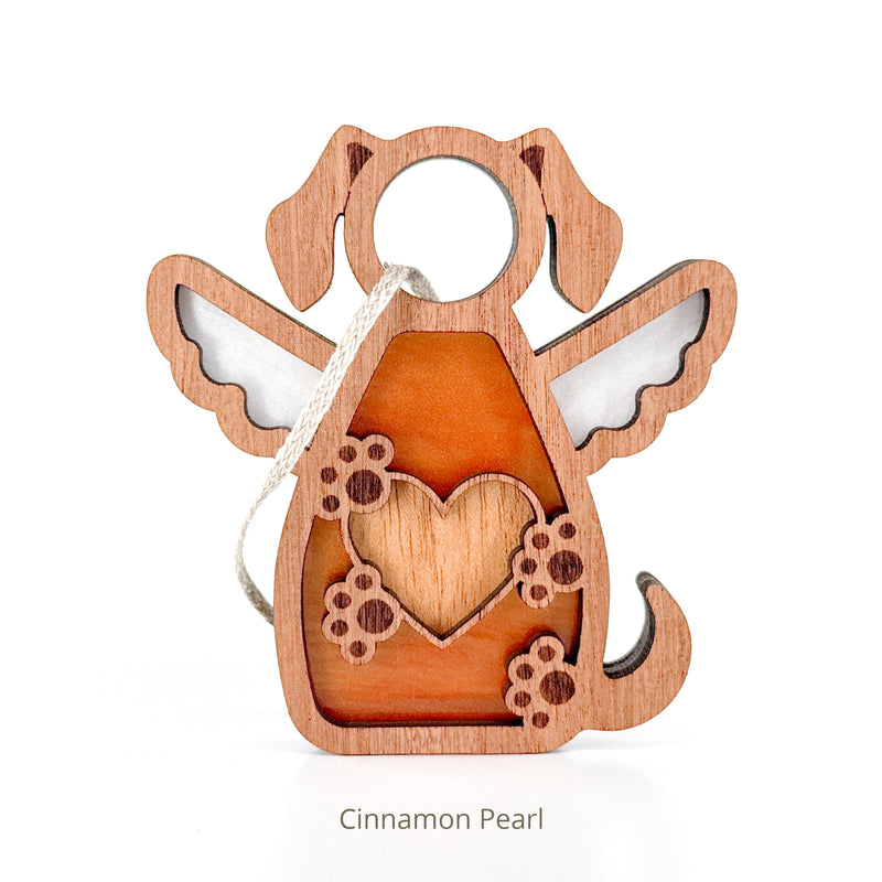 The Forged Flare® Forever In My Heart Dog Angel Ornament features a dog with angel wings, a heart cut-out, and paw prints. Finished with a string, it's an ideal dog lover gift or heartfelt memorial. Text reads "Cinnamon Pearl".