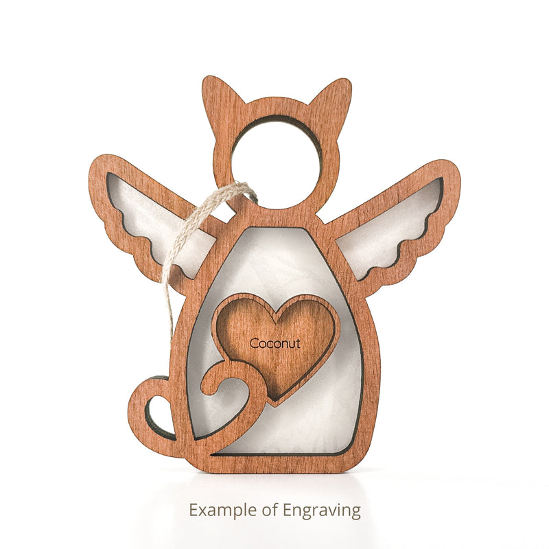 The Forged Flare® Forever Loved Cat Angel Ornament for Charity is a wooden cat ornament with angel wings and a heart engraved "Coconut," featuring a hanging string. Ideal as a personalized pet ornament or memorial. White background.