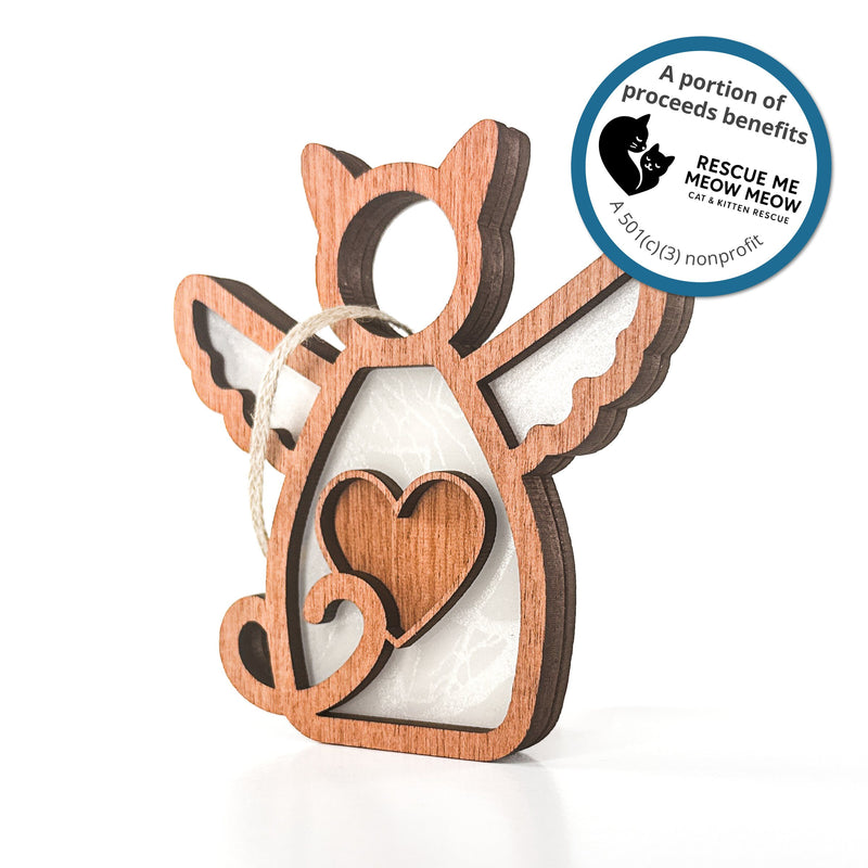 The Forged Flare® Forever Loved Cat Angel Ornament is a handcrafted cat keepsake with wings, a heart cutout, and a hanging string. Sticker text reads "A portion of proceeds benefits Rescue Me Meow Meow Cat and Kitten Rescue. A 501c3 nonprofit".