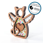 The Forever Loved Cat Angel Ornament for Charity by Forged Flare® is a handmade wooden cat with angel wings, heart cutout, and confetti. Includes string loop. Sticker text reads "A portion of proceeds benefits Rescue Me Meow Meow Cat and Kitten Rescue. A 501c3 nonprofit".