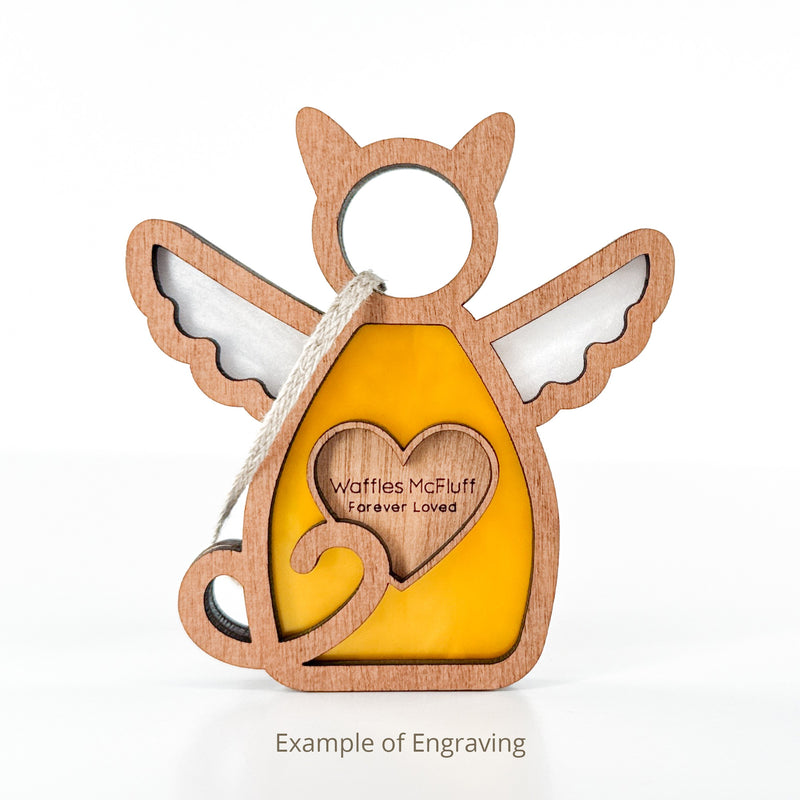 The Forged Flare® Forever Loved Cat Angel Ornament for Charity is a wooden pet ornament with a yellow body, heart-shaped engraving "Waffles McFluff Forever Loved," wings, hanging string, and cat memorial engraving sample below.