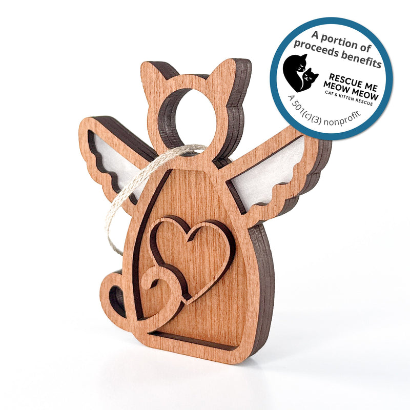 The Forged Flare® Forever Loved Cat Angel Ornament features a heart design, angel wings, and a hanging string. Sticker text reads "A portion of proceeds benefits Rescue Me Meow Meow Cat and Kitten Rescue. A 501c3 nonprofit".