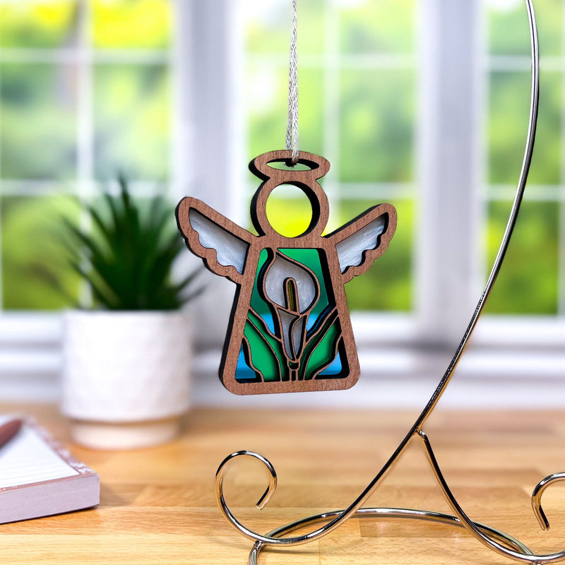 The Forged Flare® Calla Lily Ornament is a 3.5" stained glass-style angel figurine from the Mother's Angels® line, perfect as a unique Christmas tree decoration or thoughtful gift.