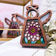 The Forged Flare® Chrysanthemum Ornament with Imperfections is a 3.5" tall Mother's Angels® handcrafted wooden angel figurine with stained glass wings and a colorful floral design, inspired by chrysanthemum centerpieces.
