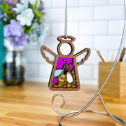 The Forged Flare® Mother's Angels® 3.5" Honey Bee Ornament is a wooden angel with a stained-glass bee and purple background, hanging from a metal stand—ideal for collectors seeking Warehouse Returns on Amazon.