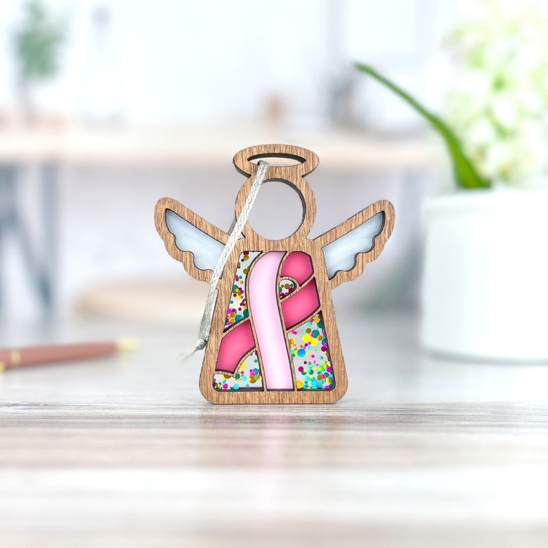 The Forged Flare® Mother's Angels® 3.5" Breast Cancer Awareness Ribbon for Charity Ornament features a stained-glass angel and pink ribbon—a heartfelt gift to honor survivors during Breast Cancer Awareness Month.