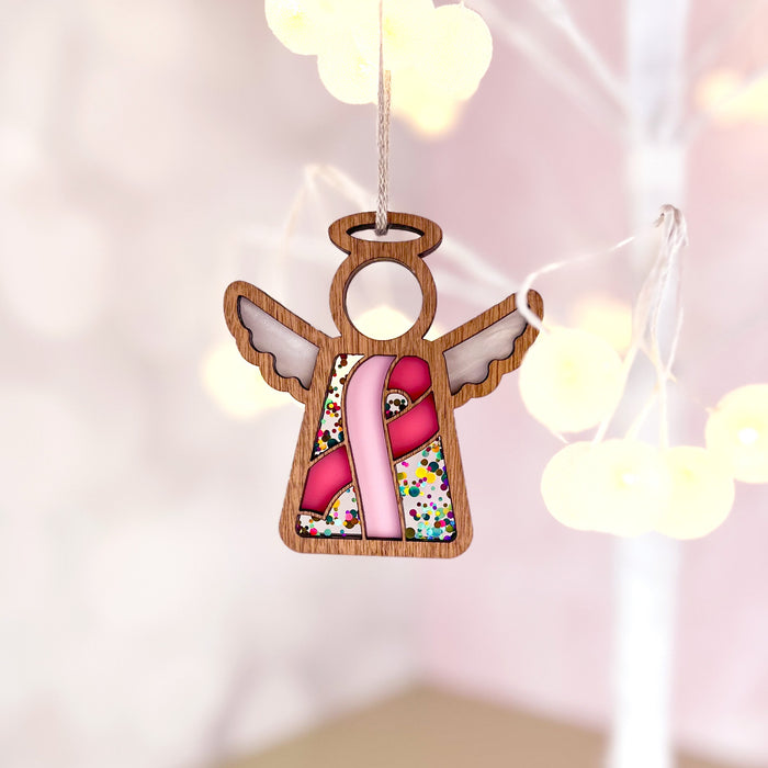 An angel ornament with a pink ribbon, a thoughtful gift for breast cancer patients and survivors, supporting awareness.