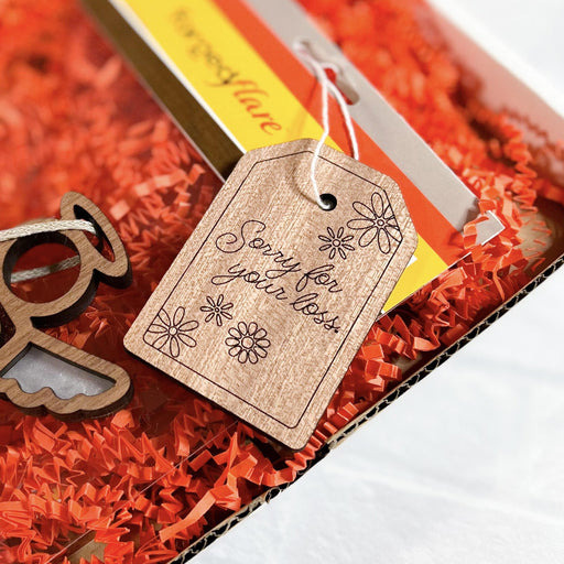 A Mother’s Angels® ornament accompanied by a handcrafted 'Sorry for your loss' tag, presented as a compassionate memorial gift and a symbolic celebration of life decoration.