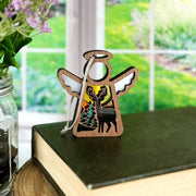 The Forged Flare® Autumn Deer Ornament | 3.5" (H) Angel Figurine by Mother's Angels® features a cut-out moose, trees, and sunset design—perfect as an autumn decor piece or deer hunter gift for your window or bookshelf.