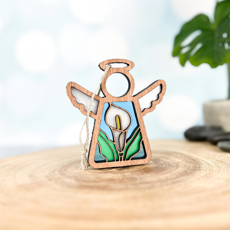 The Forged Flare® Mother's Angels® Calla Lily Ornament is a 3.5" wooden angel figurine with a stained glass-style white calla lily design—perfect as a unique Christmas tree ornament or thoughtful gift.