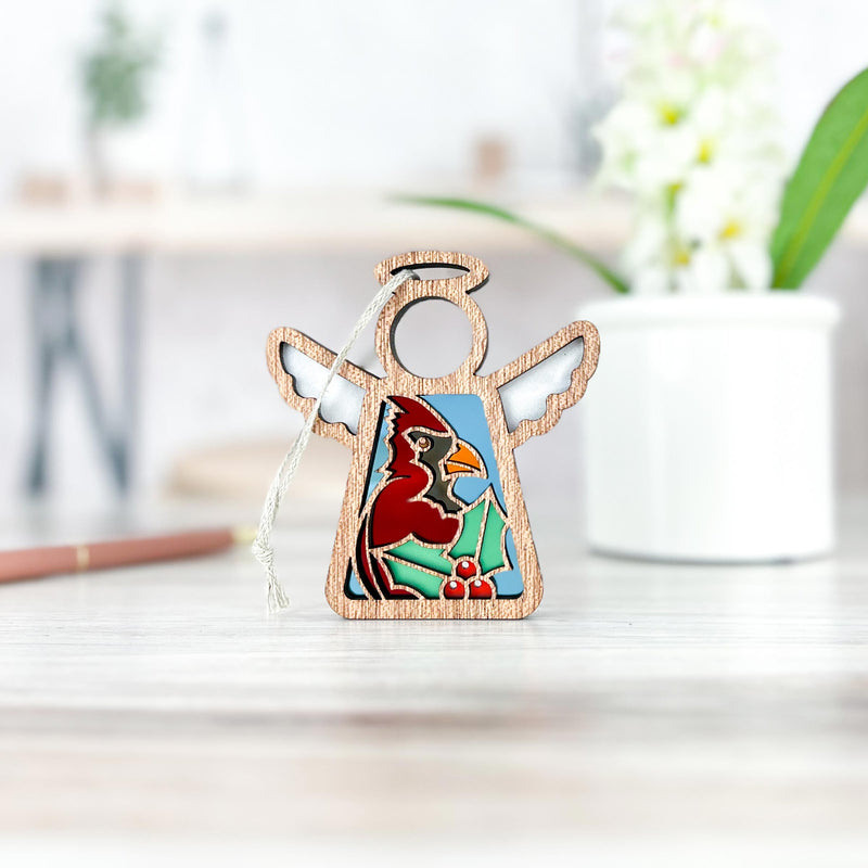 The Forged Flare® Winter Cardinal Ornament with Imperfections is a 3.5" handcrafted Mother's Angels® figurine featuring a painted red cardinal and holly—a charming collectible for your angel collection.