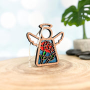 The Forged Flare® Carnation Ornament | 3.5" (H) Angel Figurine from Mother's Angels® features stained-glass style carnations—April’s birth flower—in a wooden angel with cutout wings and halo, ready to hang.