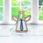 The Forged Flare® Forever Your Father Ornament, a 3.5" Mother's Angels® figurine with white wings and a blue patterned tie, stands on a white surface—perfect for Father's Day—with a blurred window and green background behind.