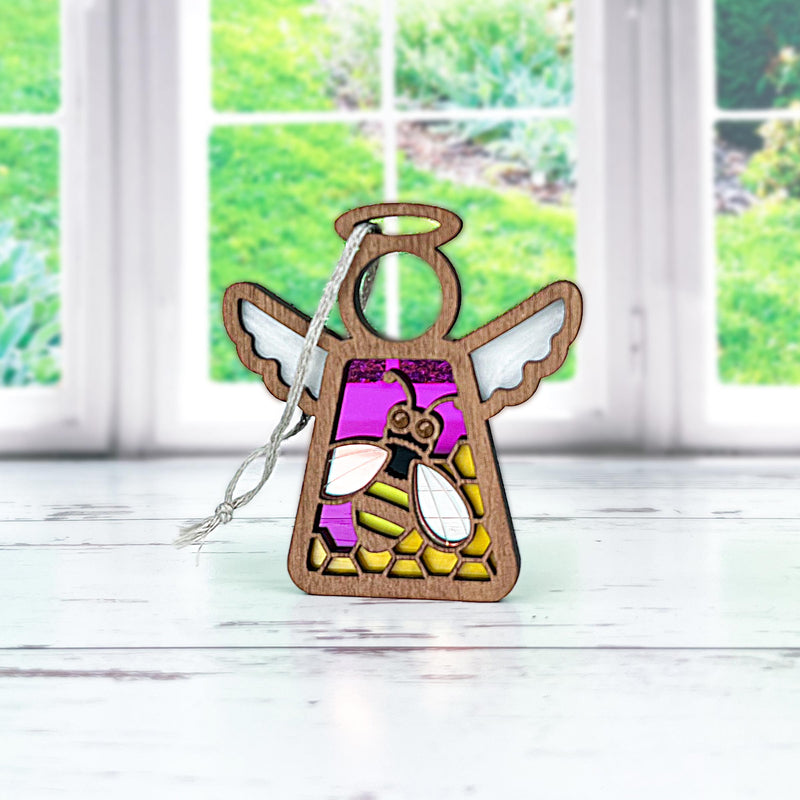The Forged Flare® Mother's Angels® Honey Bee Ornament is a 3.5" wooden angel figurine with stained glass-style wings and bee details in purple and yellow—ideal for collectors shopping Amazon warehouse returns.