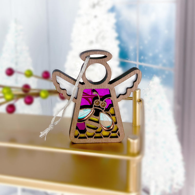 The Forged Flare® Warehouse Return - Honey Bee Ornament is a 3.5" stained glass-style Mother's Angels® figurine featuring pink, purple, and gold accents. It sits on a gold shelf—a lovely Amazon marketplace find for festive decor.