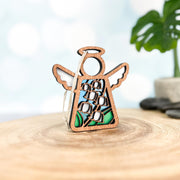 The Forged Flare® Lily of the Valley Ornament is a 3.5" Mother's Angels® wooden angel figurine with wings and a halo, featuring a stained glass-style lily of the valley design, perfect for celebrating May birthdays.