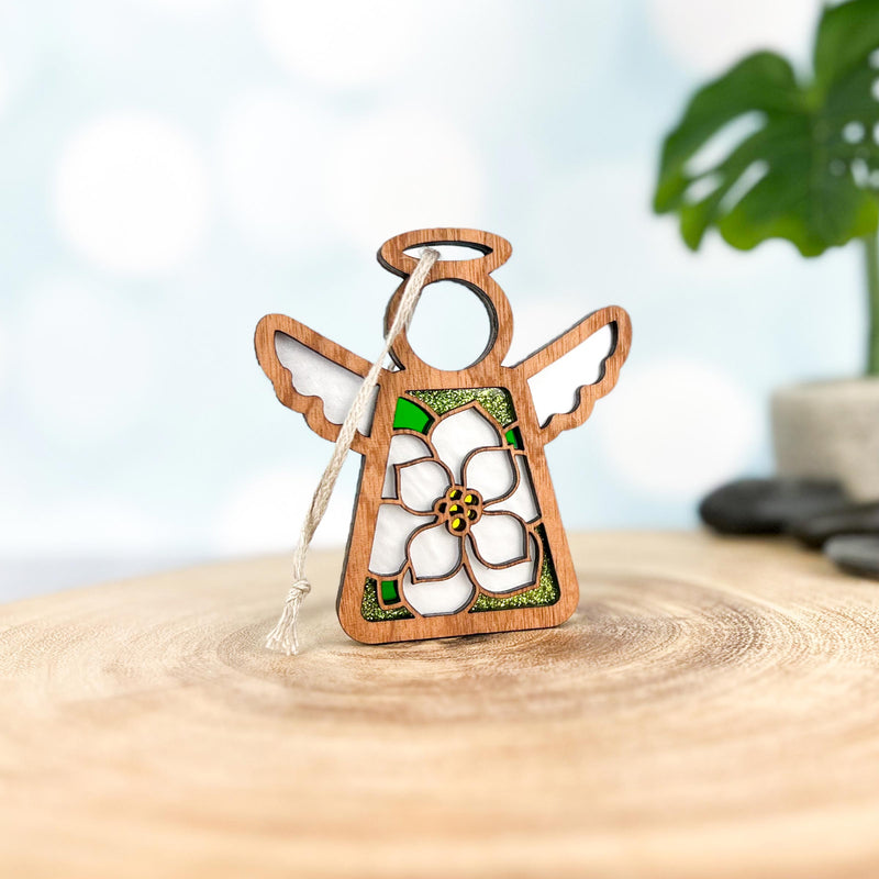 The Forged Flare® Magnolia Ornament is a 3.5" Mother's Angels® figurine with white wings and a halo, featuring a central magnolia accent—perfect for your Christmas tree or as festive décor. Stands on any smooth surface; plant not included.