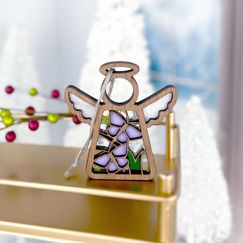 The Forged Flare® Mother's Angels® 3.5" Playful Purple Butterflies Ornament features stained glass-style wings and purple accents, displayed on a gold shelf with festive décor—ideal for collectors shopping on Amazon.