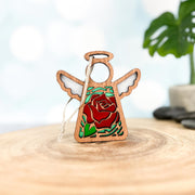 The Forged Flare® Mother's Angels® 3.5" Red Rose Ornament with Imperfections features a handcrafted angel with stained-glass effect, red rose centerpiece, green leaves, and hanging string—perfect as a collectible wooden figurine.