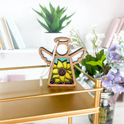 The Forged Flare® Warehouse Return - Sunflower Ornament is a 3.5" Mother's Angels® stained-glass-style angel figurine, ideal for collectors or as Amazon warehouse inventory. Display with books, plants, and flowers for a charming touch.