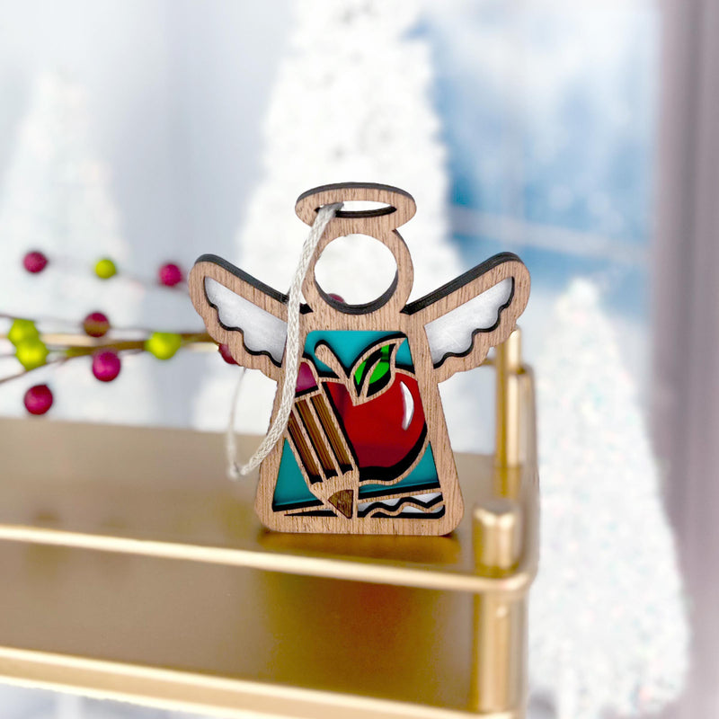 The Forged Flare® Teacher Ornament with Imperfections is a 3.5" handcrafted Mother's Angels® figurine featuring painted apple and pencil details—ideal as a teacher-themed centerpiece among festive décor.