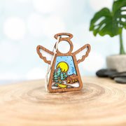 The Forged Flare® Warm Welcome Ornament with Imperfections is a 3.5" handcrafted Mother's Angels® angel figurine, featuring a cutout snowy cabin scene—perfect as a log cabin centerpiece or unique collectible.