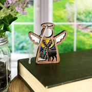 The Forged Flare® Winter Deer Ornament is a 3.5" Mother's Angels® wooden angel figurine, featuring a deer, trees, and mountains scene—perfect as charming deer decor for winter.