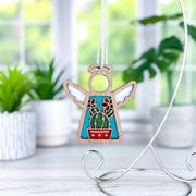The Forged Flare® Desert Cactus Ornament is a 3.5" Mother's Angels® angel figurine with wings and a red potted cactus design, displayed on a curved stand—perfect for charming Southwest-inspired decor.