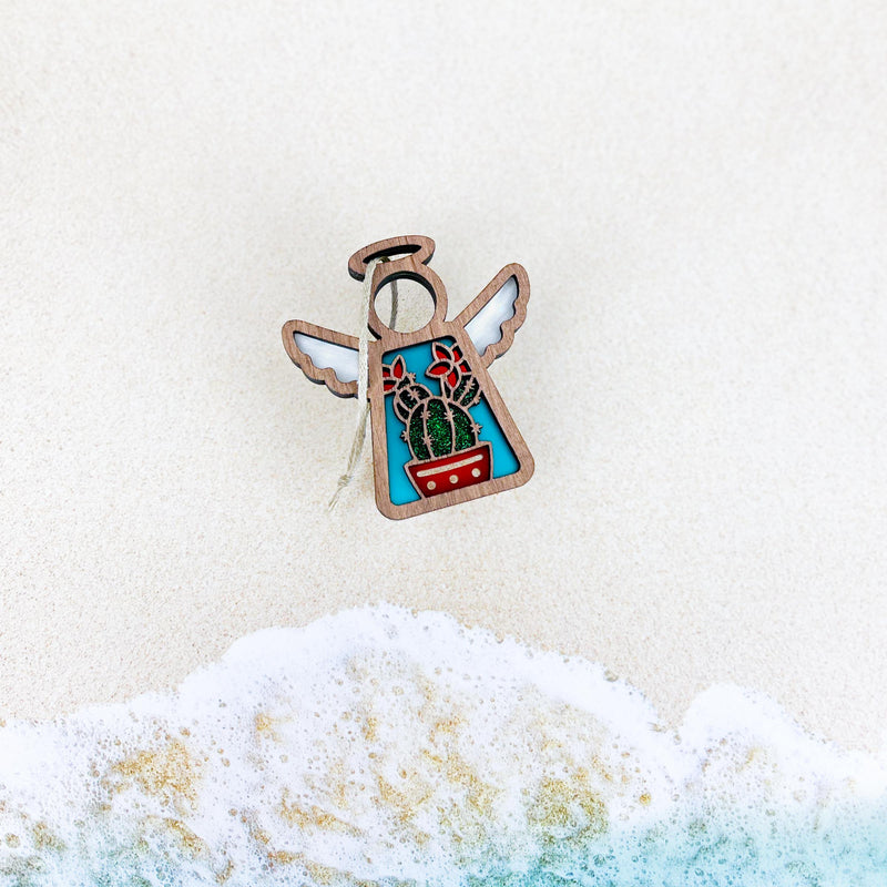 The Forged Flare® Desert Cactus Ornament, a 3.5" Mother's Angels® figurine, showcases angelic cactus and flower designs inspired by Southwest decor—perfect as a unique decorative accent.