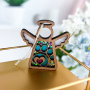 The Forged Flare® Paw Print Ornament with Imperfections is a 3.5" Mother's Angels® angel figurine featuring blue paw prints, a pink heart, and a glittery gold background—an ideal pet memorial or caring pet loss gift.