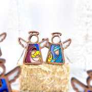 The Forged Flare® Christmas Nativity 2-Piece Bundle features 3.5" Mother's Angels® figurines of Mary with Baby Jesus and Joseph, both with stained-glass accents and snowy white backgrounds.