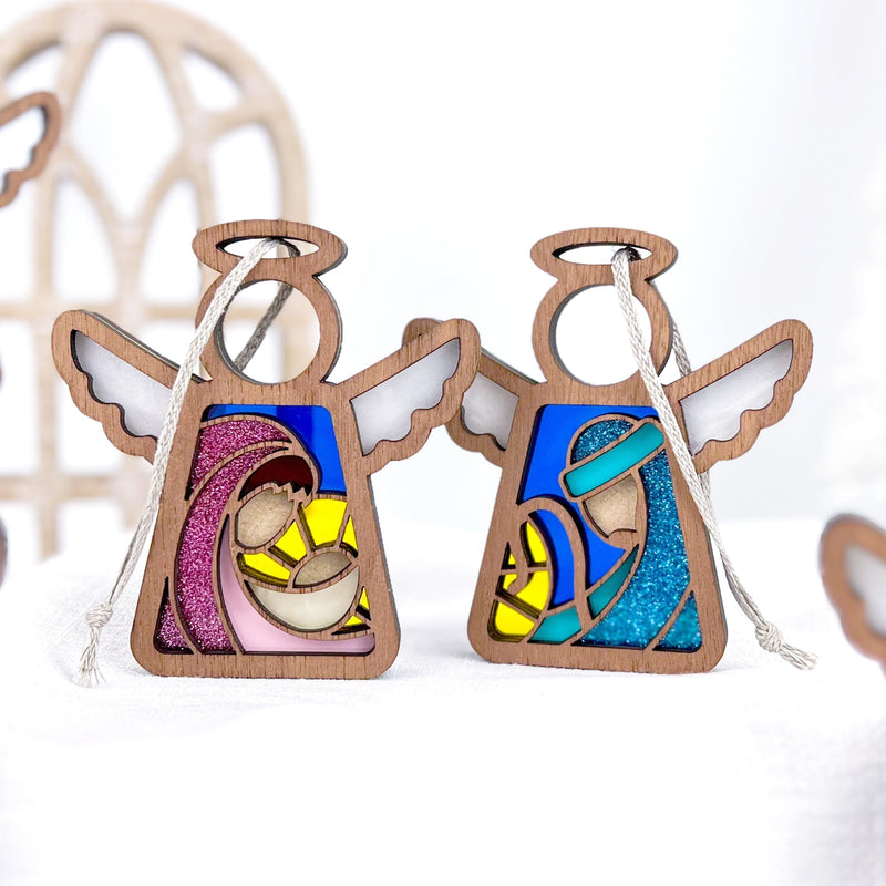 The Forged Flare® Christmas Nativity 2-Piece Bundle features two 3.5" stained glass-style Mother's Angels® ornaments—Mary and Joseph—displayed on a white surface with a softly blurred background.