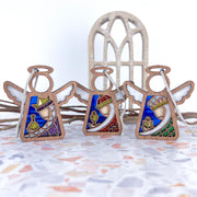 The Forged Flare® Christmas Nativity 3-Piece Bundle features 3.5" Mother's Angels® figurines of the Three Wise Men, displayed on terrazzo with a rustic arched window and twigs—perfect for unique holiday decor.