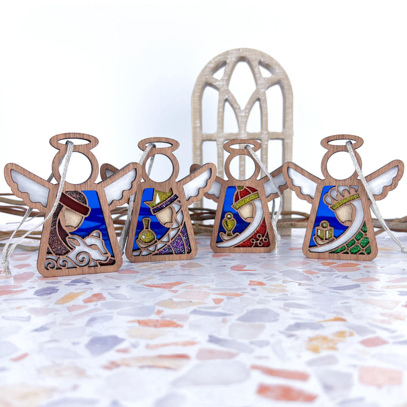 The Forged Flare® Christmas Nativity 4-piece bundle features 3.5" stained-glass style Mother's Angels® figurines—Three Wise Men and a Shepherd—displayed on terrazzo with a decorative arched window in the background.