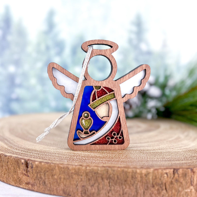 The Forged Flare® Christmas Nativity Red Wise Man is a 3.5" (H) Mother's Angels® figurine featuring stained glass-style wings and robe in red, blue, and green with a gold anchor, ideal as a unique Nativity gift or ornament.