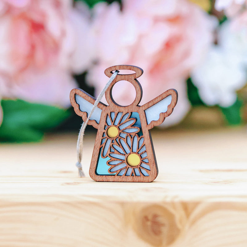 The Forged Flare® Warehouse Return - Daisy Ornament is a 3.5" Mother's Angels® figurine with blue wings, yellow daisies, and a twine loop—ideal for collectors and available on Amazon.