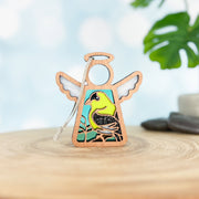 The Forged Flare® Goldfinch Ornament is a 3.5" wooden angel figurine from Mother's Angels®, featuring a painted yellow and black bird—a unique gift for bird lovers, complete with hanging string and natural accents.
