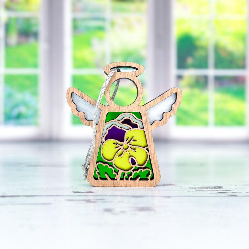 The Forged Flare® Pansy Ornament | 3.5" (H) Angel Figurine from Mother's Angels® features a small wooden angel with yellow and purple pansies—ideal for your Christmas tree or angel figurine collection.